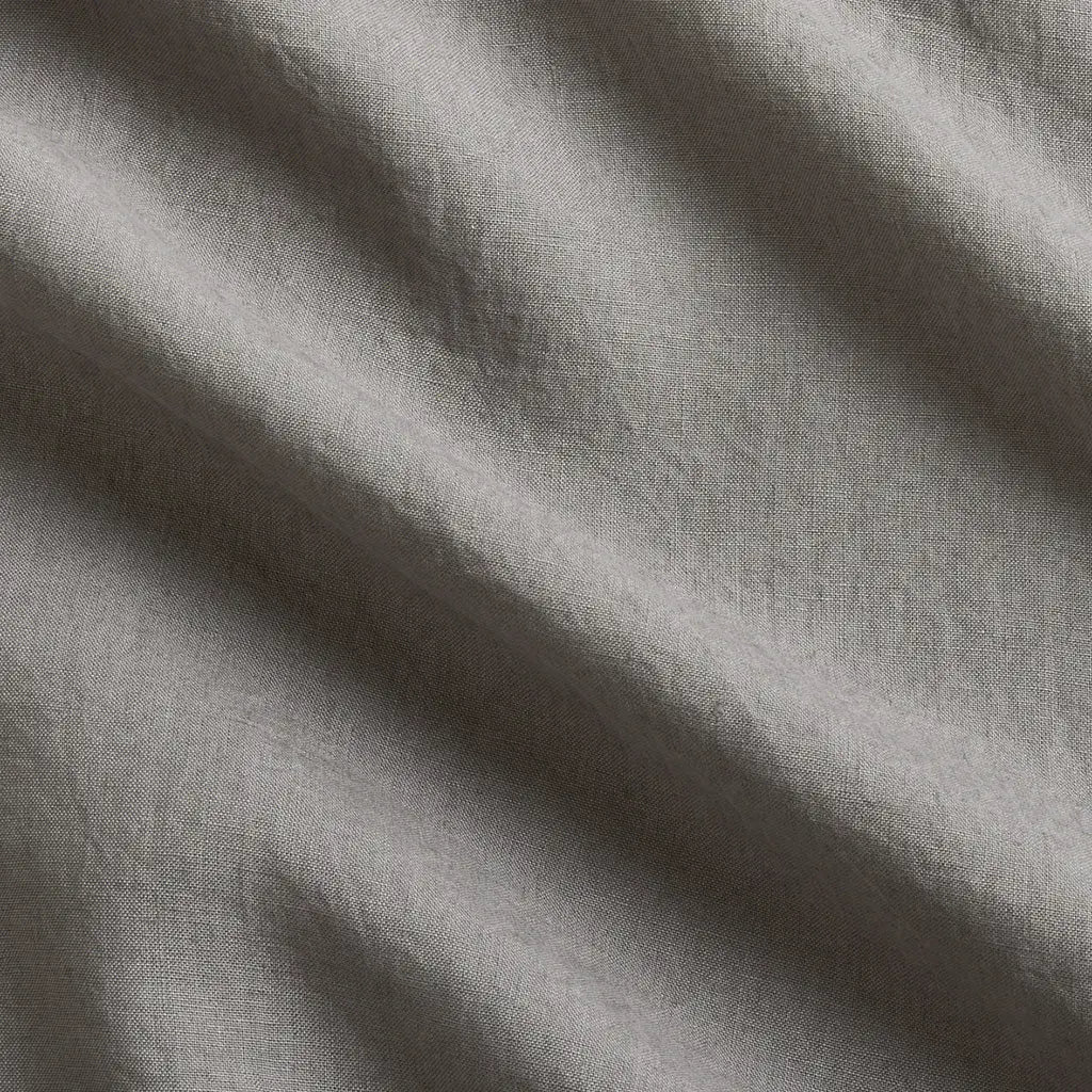 Close-up of a grey washed-linen sheet set, showing the fabric's texture and natural wrinkles.
