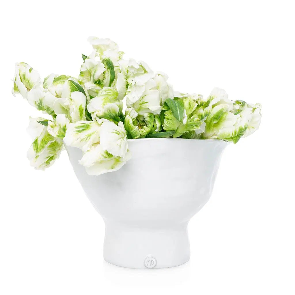 Handmade creamy white ceramic pedestal bowl by Montes Doggett, filled with green and white tulips.