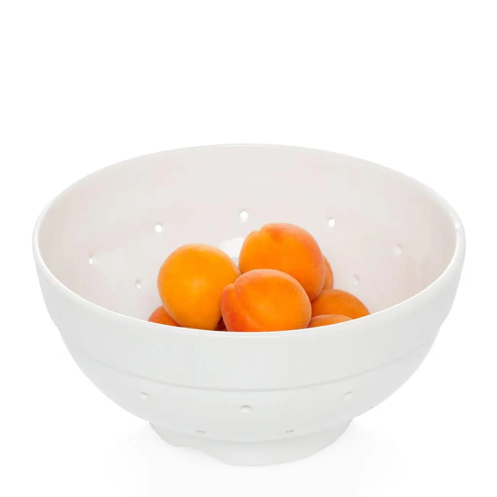 Hudson Grace white ceramic colander, vintage-inspired, with apricots inside.