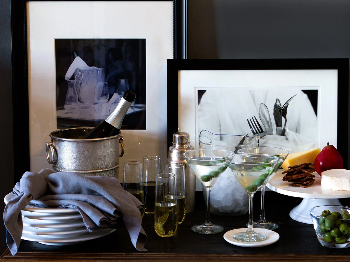 Large handblown glass ice bucket with handles, holding a champagne bottle.