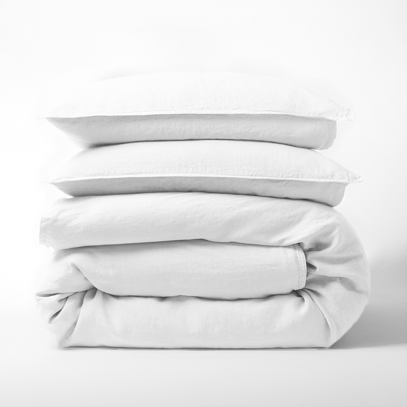 Stack of white Washed-Linen Duvet Cover and two pillow shams.