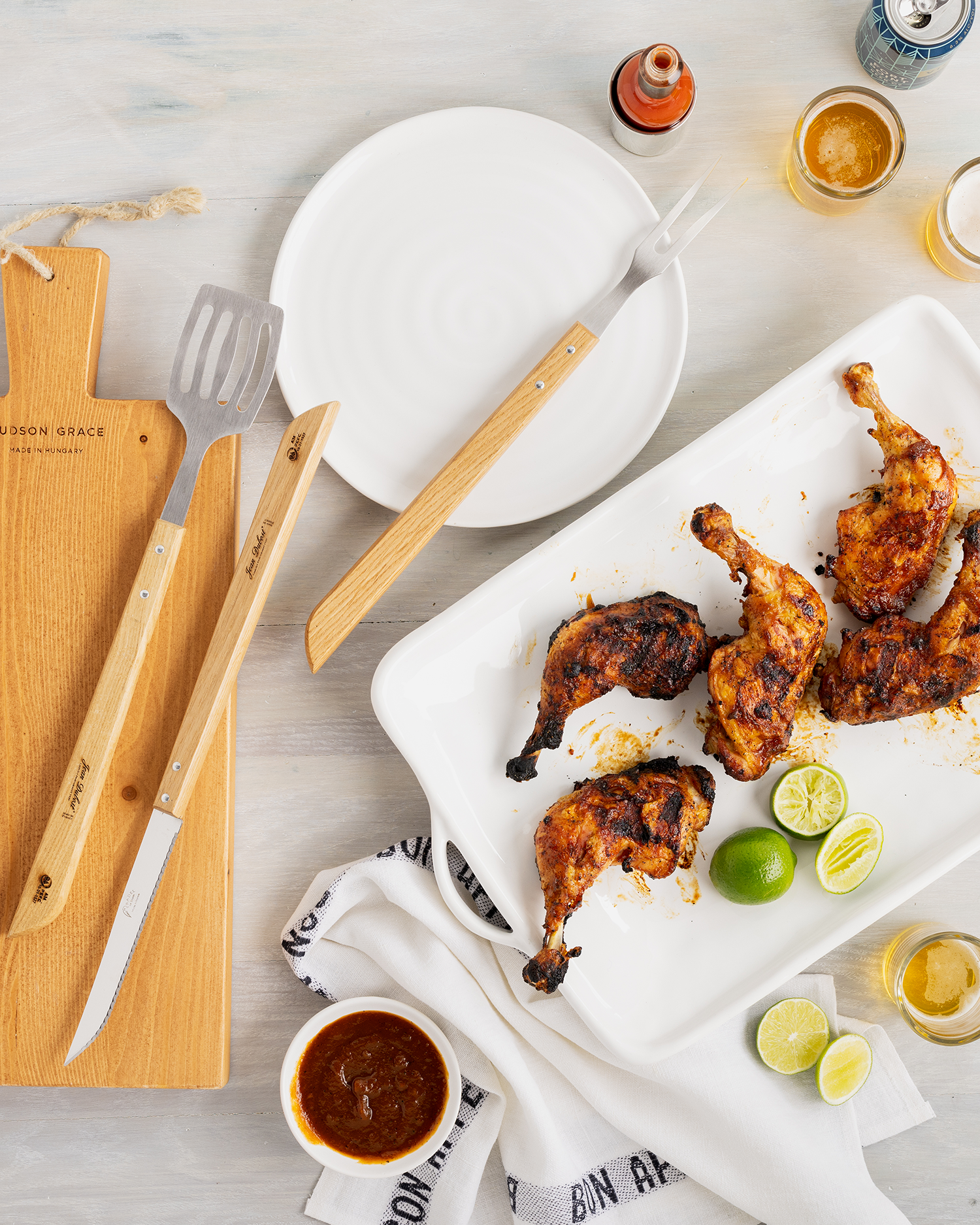 Grilled chicken legs, lime, and BBQ tools for Long Weekend Entertaining.