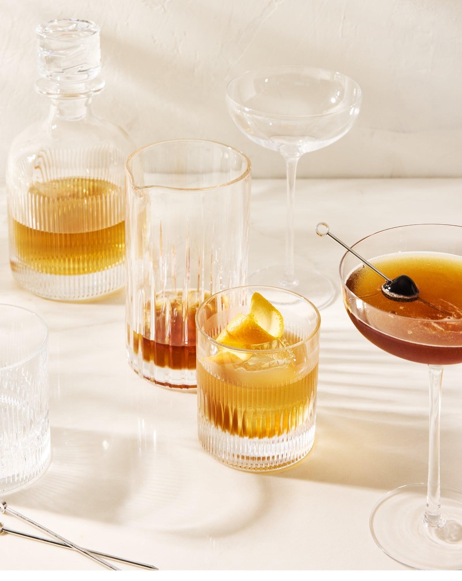 Thanksgiving barware: ribbed glass decanter, cocktail glasses with drinks, and martini coupe.