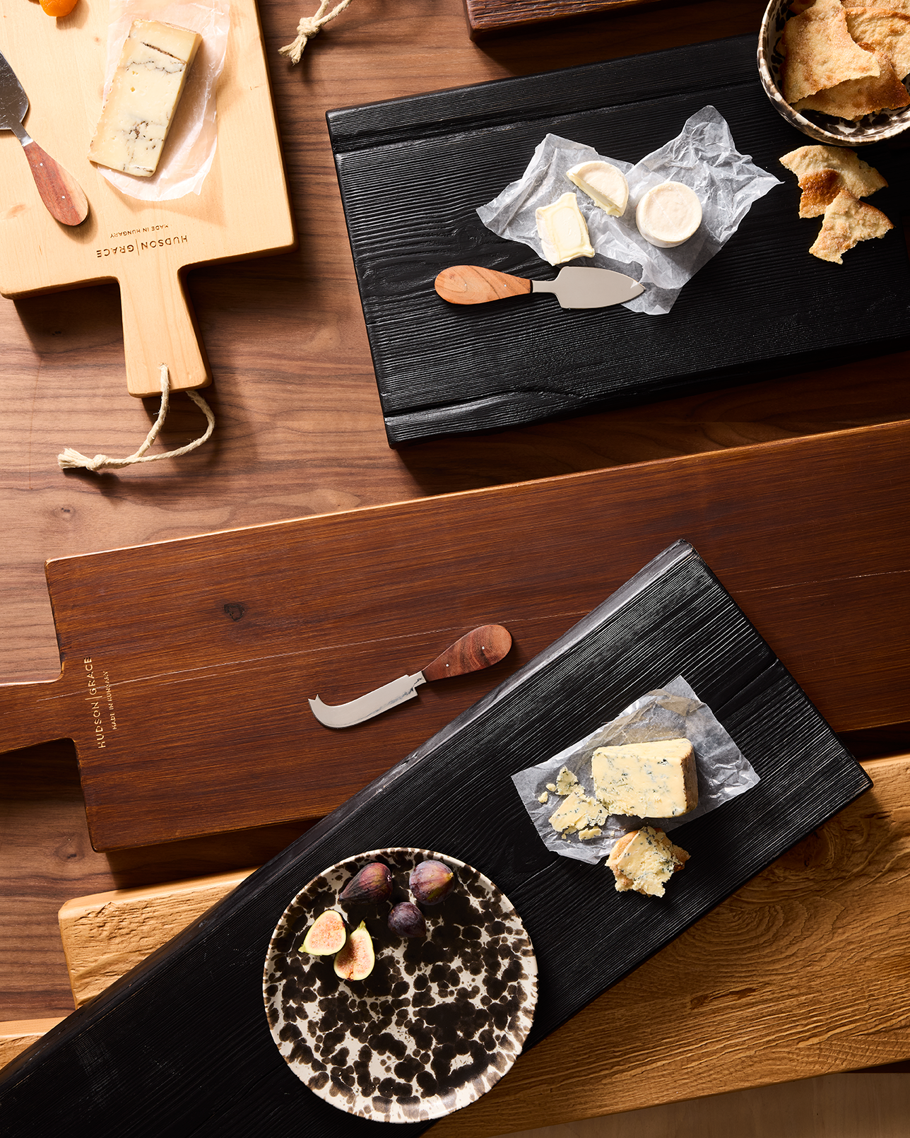 Assorted wooden cheese boards with various cheeses, figs, and crackers for a Wine & Cheese Night.