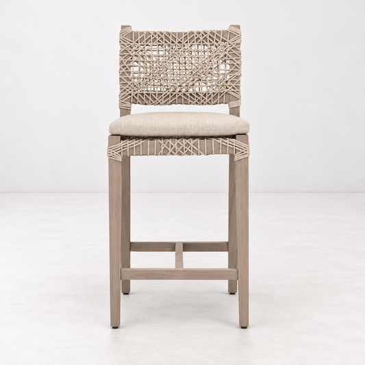 Costa outdoor counter stool with washed teak frame, woven oat-colored rope back, and ecru olefin fabric seat cushion.