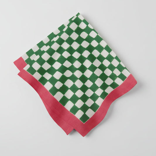 Green and white checkered napkin with red border on a white background