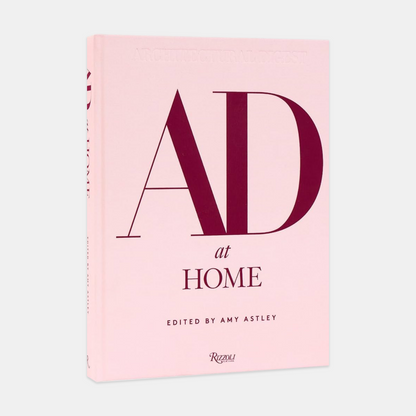 AD at Home hardcover book, light pink cover with large burgundy "AD" and "at HOME" text.