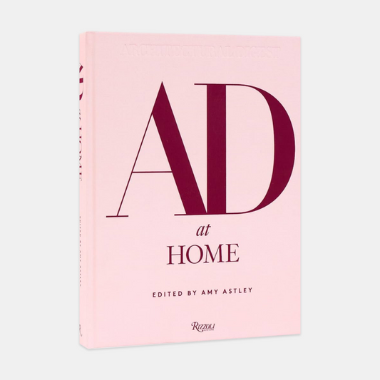 AD at Home hardcover book, light pink cover with large burgundy "AD" and "at HOME" text.