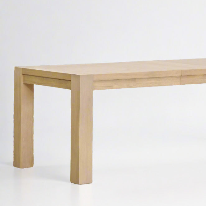 Adler Extension Dining Table in light honey oak finish with wood veneer top and thick legs.