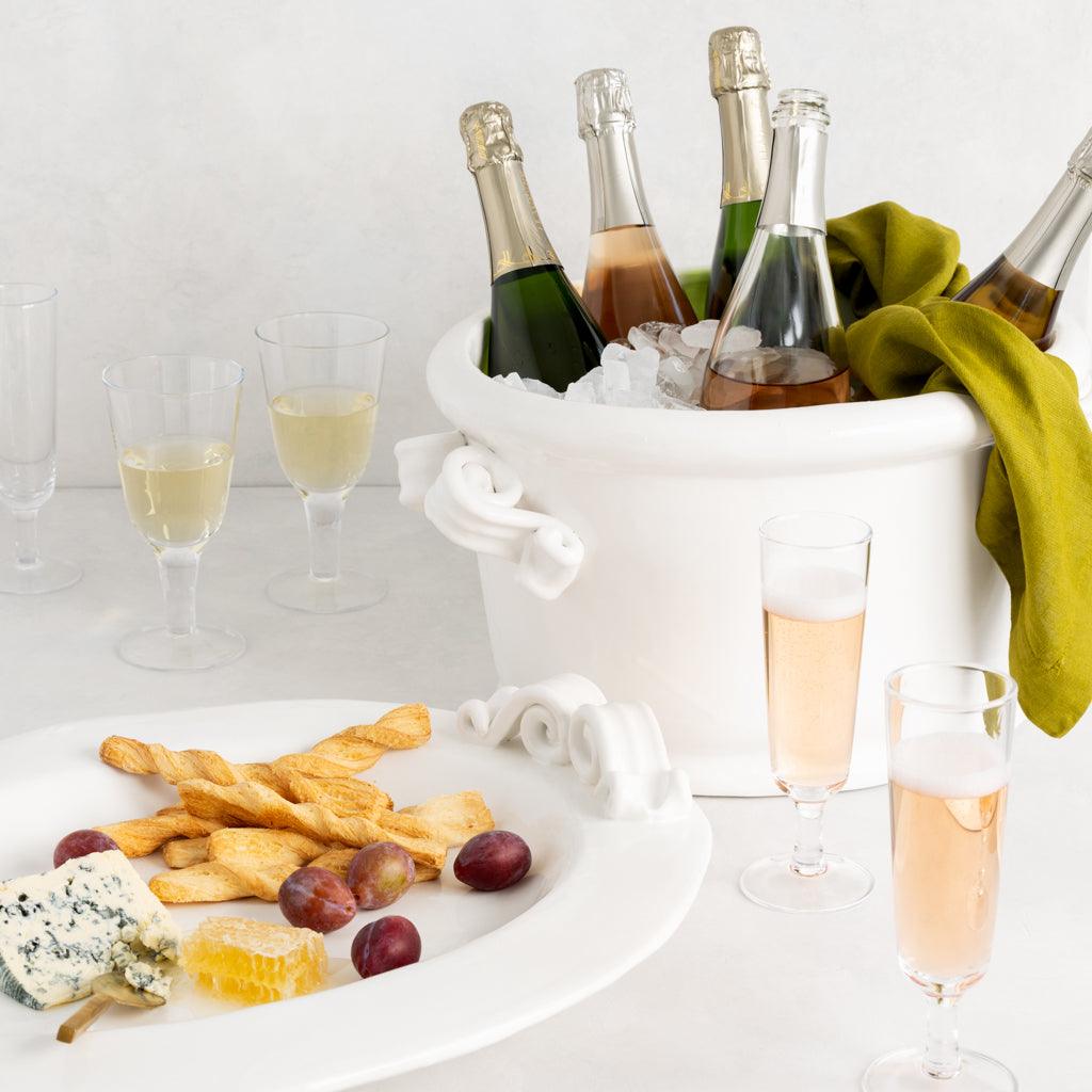Aloe Green HG Signature Hand-dyed Linen Napkin draped over a white ice bucket with champagne bottles.