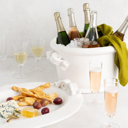 Aloe Green HG Signature Hand-dyed Linen Napkin draped over a white ice bucket with champagne bottles.