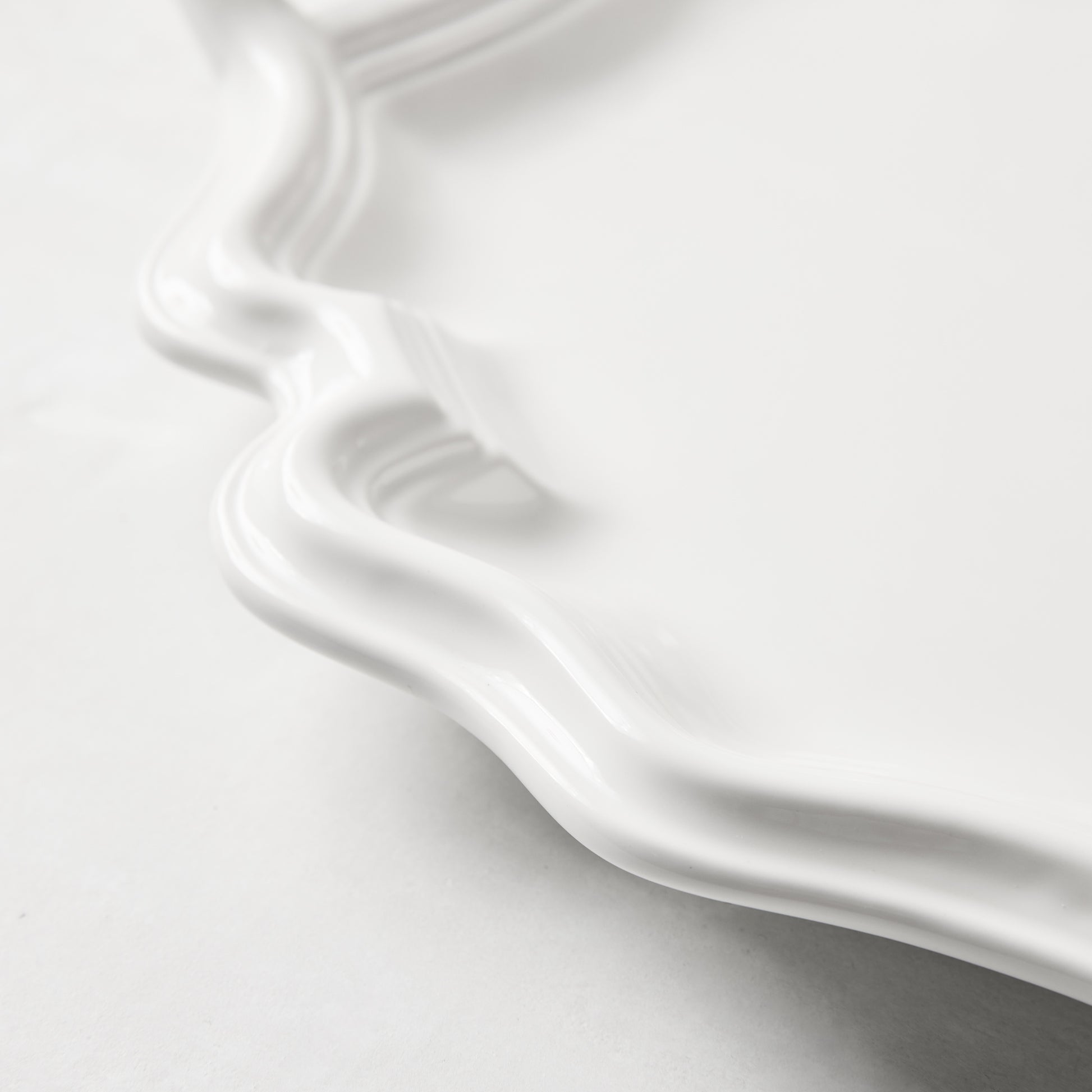 White ceramic Amalfi serving platter with scalloped edge and integrated handles.