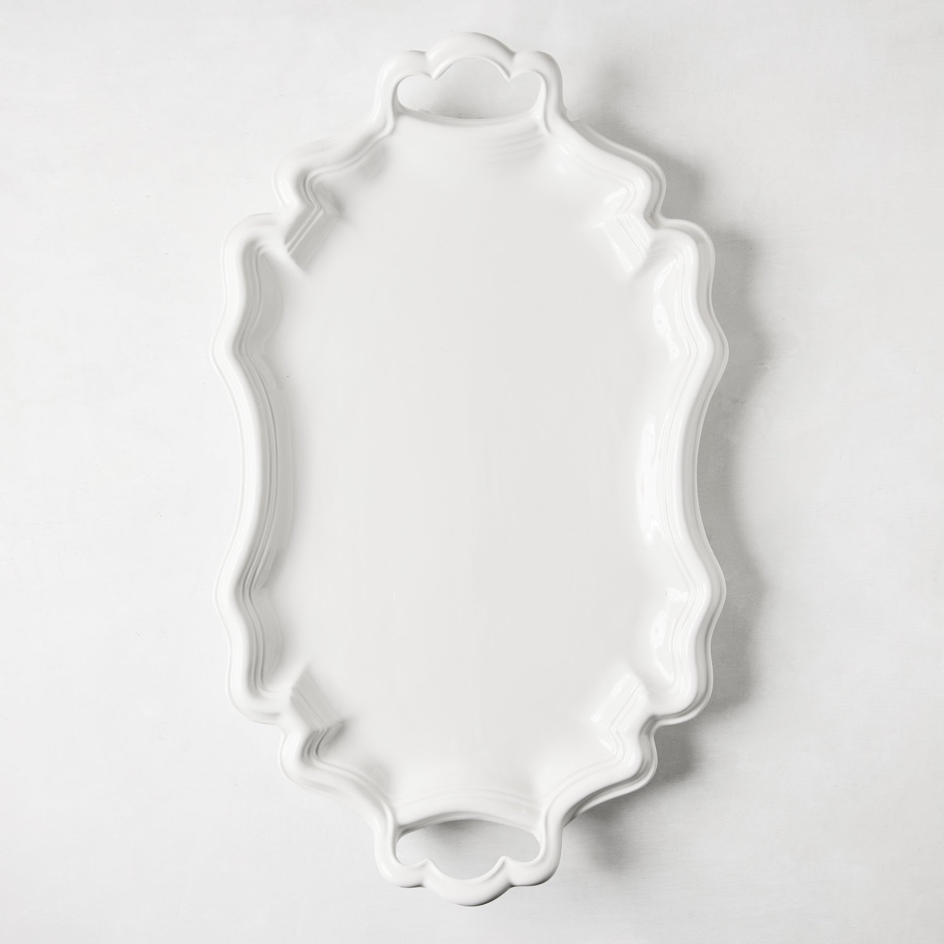 Amalfi white ceramic serving platter with scalloped edges and integrated handles.