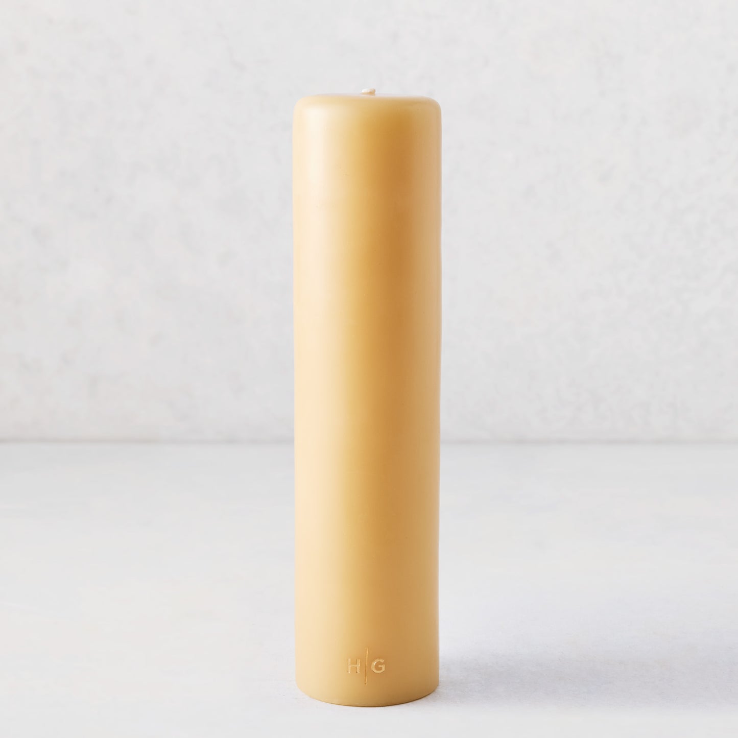 3x12 amber unscented pillar candle with a gold HG logo, hand-dipped from natural paraffin and tree resin.