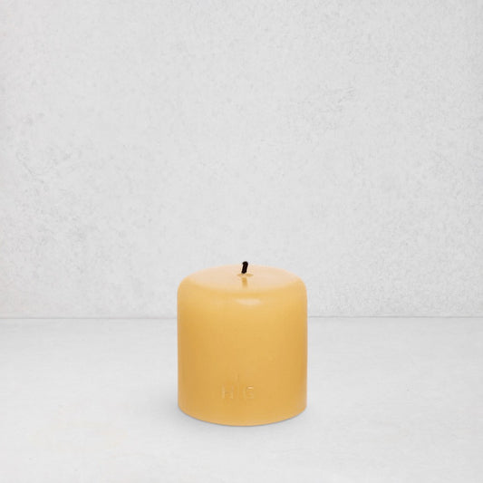 HG Amber Unscented Pillar Candle, 3"x3", with a gold embossed HG logo and black wick.