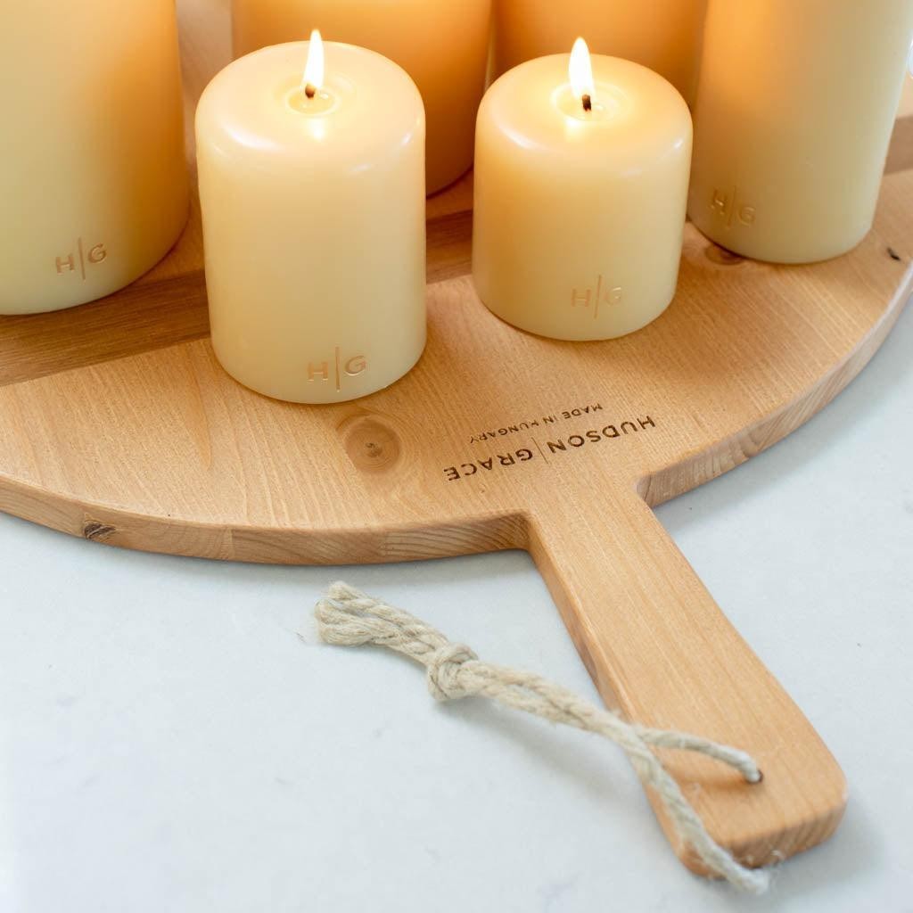 HG Amber Unscented 3"x4" pillar candle, hand-dipped paraffin, with gold HG logo, on a wood board.