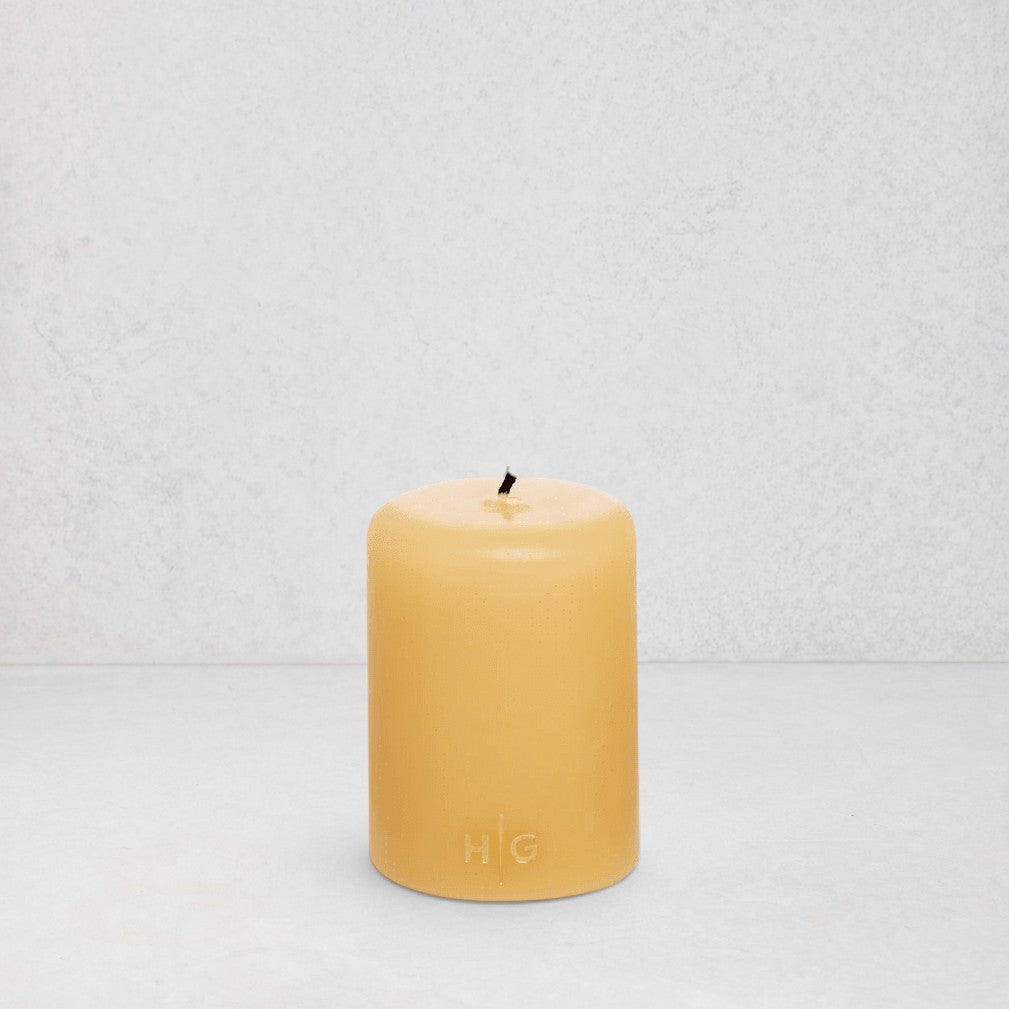 HG Amber Unscented Pillar Candle, 3"x4", hand-dipped paraffin with gold HG logo.