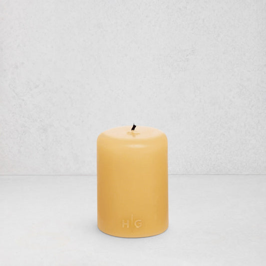 HG Amber Unscented Pillar Candle, 3"x4", hand-dipped paraffin with gold HG logo.