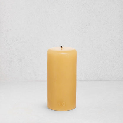 HG Amber Unscented 3"x6" paraffin pillar candle with gold embossed HG logo and cotton wick.