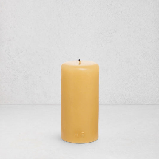 HG Amber Unscented 3"x6" paraffin pillar candle with gold embossed HG logo and cotton wick.