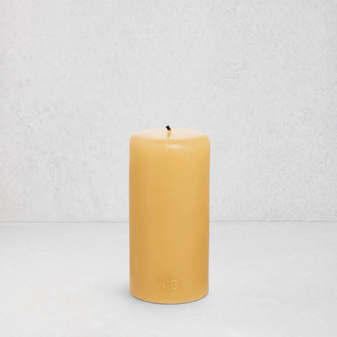 HG Amber Unscented 3"x6" paraffin pillar candle with gold embossed HG logo and cotton wick.