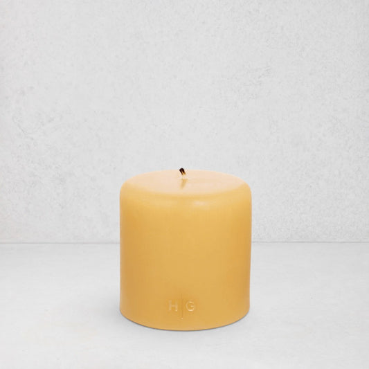 HG Amber Unscented Pillar Candle, 4"x4" paraffin with gold embossed HG logo and cotton wick.