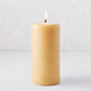 4x8 inch amber unscented pillar candle with a lit cotton wick and gold embossed HG logo on a light background.