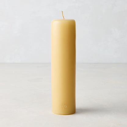 HG Amber Unscented Taper Candle, 7" x 1 3/4", natural paraffin with embossed gold HG logo.