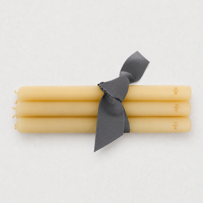 Set of five 15-inch amber unscented taper candles with gold HG logo, tied with a grey ribbon.