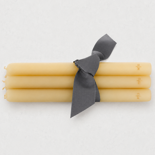 Set of five 17-inch amber hand-dipped taper candles with gold HG logo, tied with a grey ribbon.