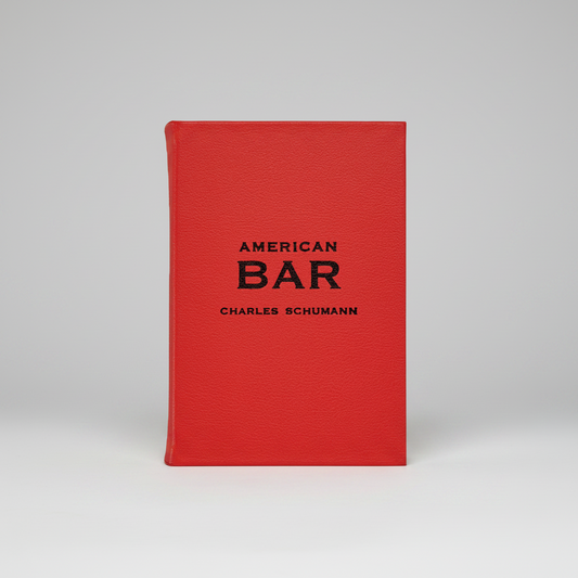 Red leather-bound American Bar book by Charles Schumann with black text.