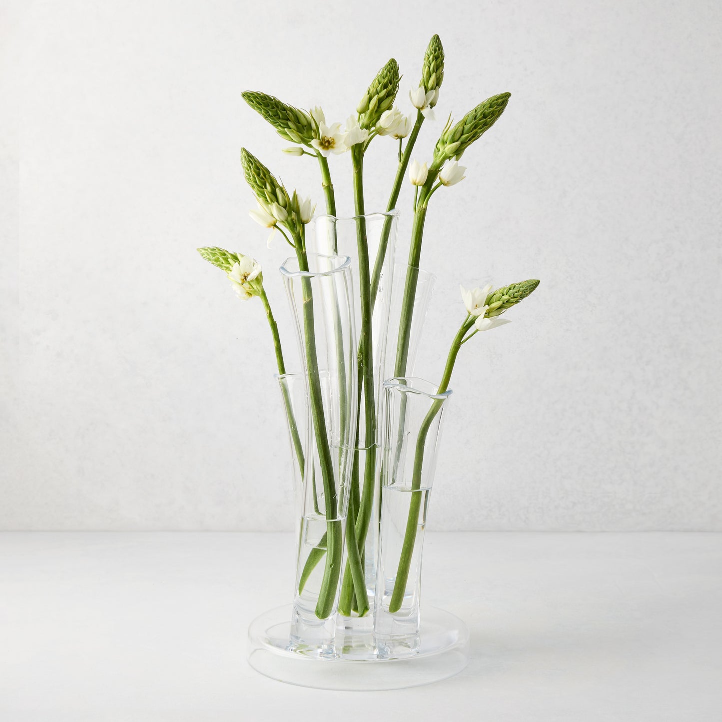 Angelina Small Scissor-Cut Glass Vase, clear, handmade, with stair-step fluted tubes and white flowers.