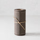Roll of 50 anthracite grey tear-off cotton cocktail napkins with white stitched border, tied with twine.