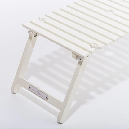 Antique white slatted hardwood outdoor picnic table with folding legs and wine glass holders.
