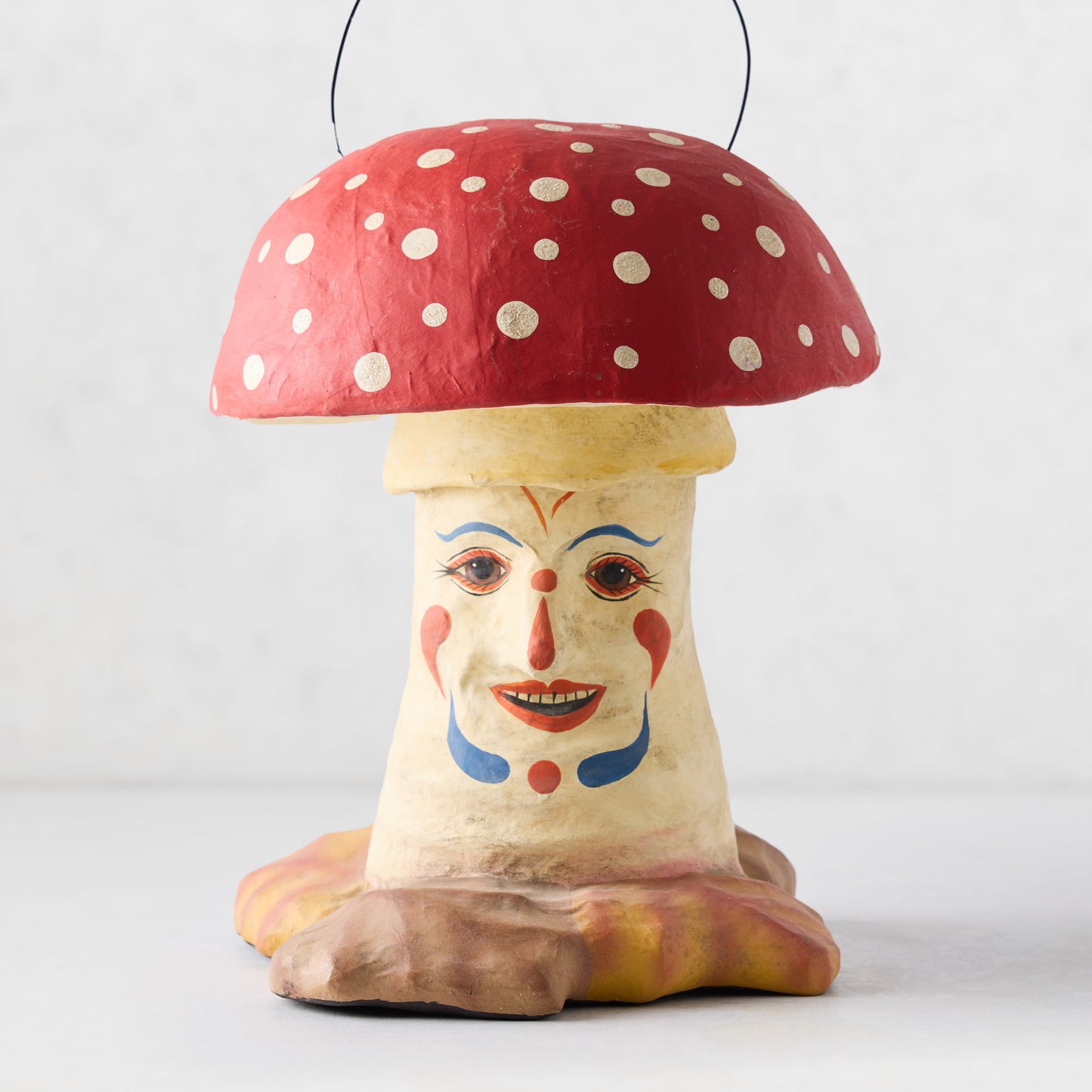 Vintage-style papier-mâché mushroom candy bucket with red polka-dot cap and hand-painted clown face on a cream stem.