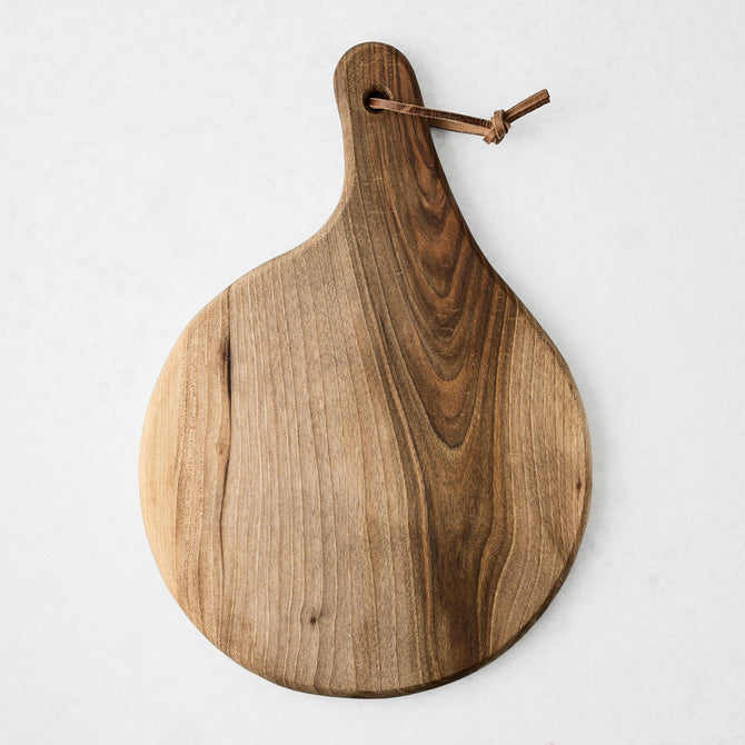 Artisan round walnut wood serve board with a leather hanging cord.