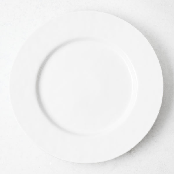 11-inch creamy white artisan stoneware dinner plate with a wide rim, viewed from directly above.