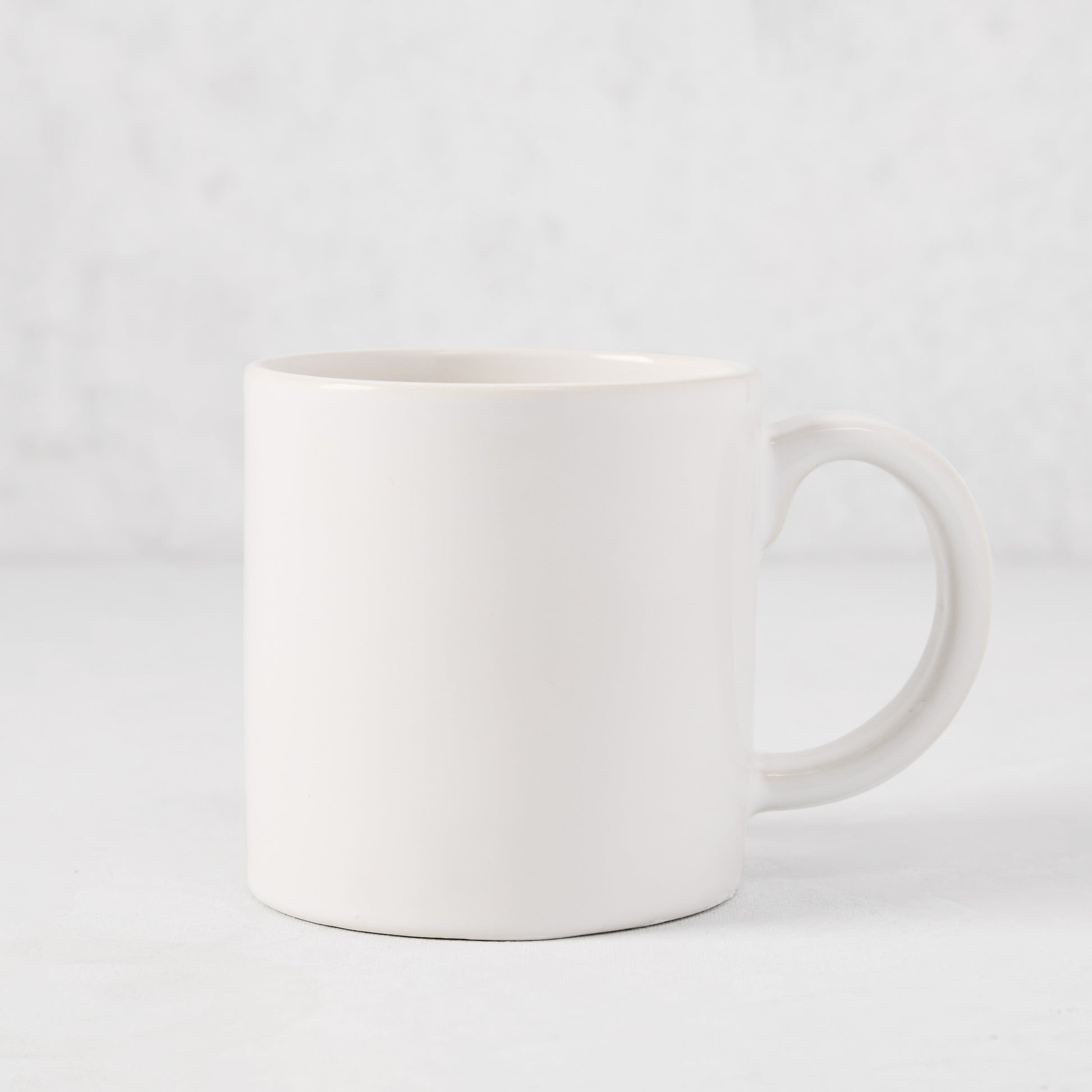 Artisan Stoneware Mug, creamy white glaze, large handle, clean edges.
