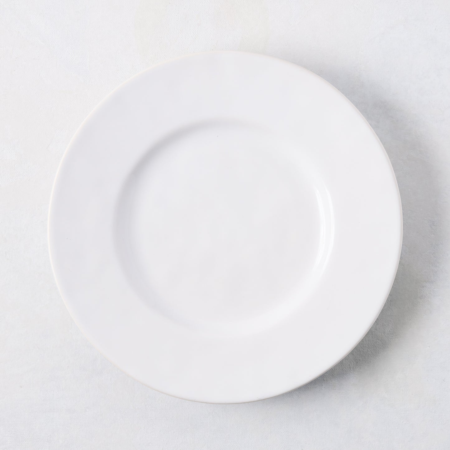 Artisan creamy white stoneware salad plate, 8.27"Dia, with a wide lip.