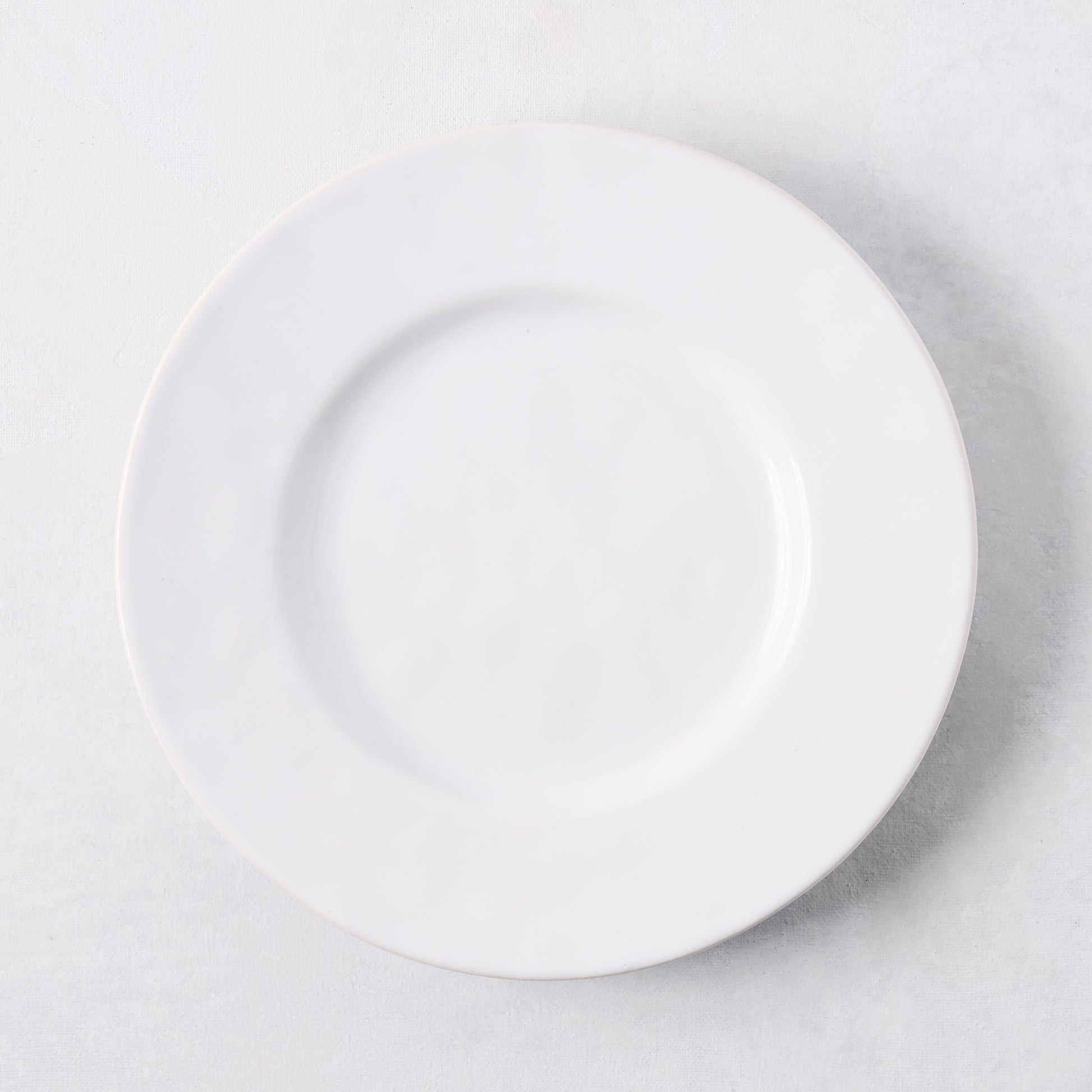 Artisan creamy white stoneware salad plate, 8.27"Dia, with a wide lip.