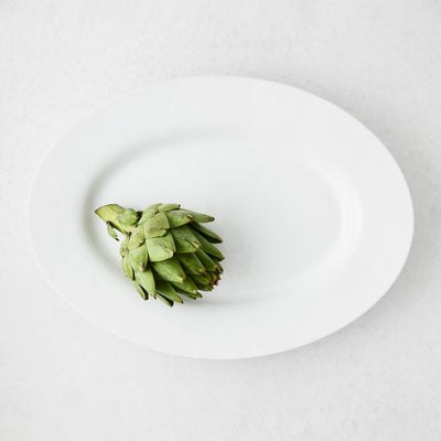 Artisan Stoneware Serve Platter, creamy white, with a single green artichoke.