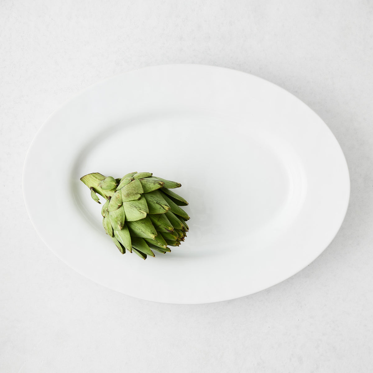 Artisan Stoneware Serve Platter, creamy white, with a single green artichoke.