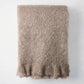 Ashwood Brown Mohair Throw Blanket, folded, with a soft, fuzzy texture and fringed edge.