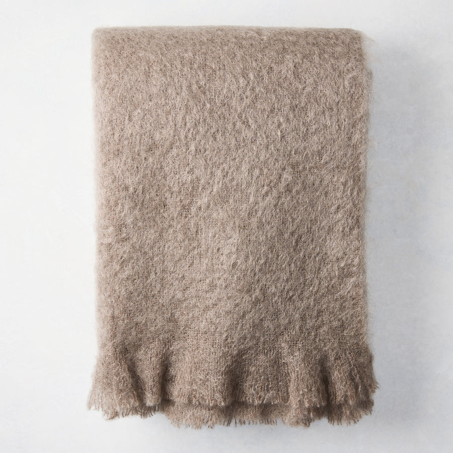 Ashwood Brown Mohair Throw Blanket, folded, with a soft, fuzzy texture and fringed edge.