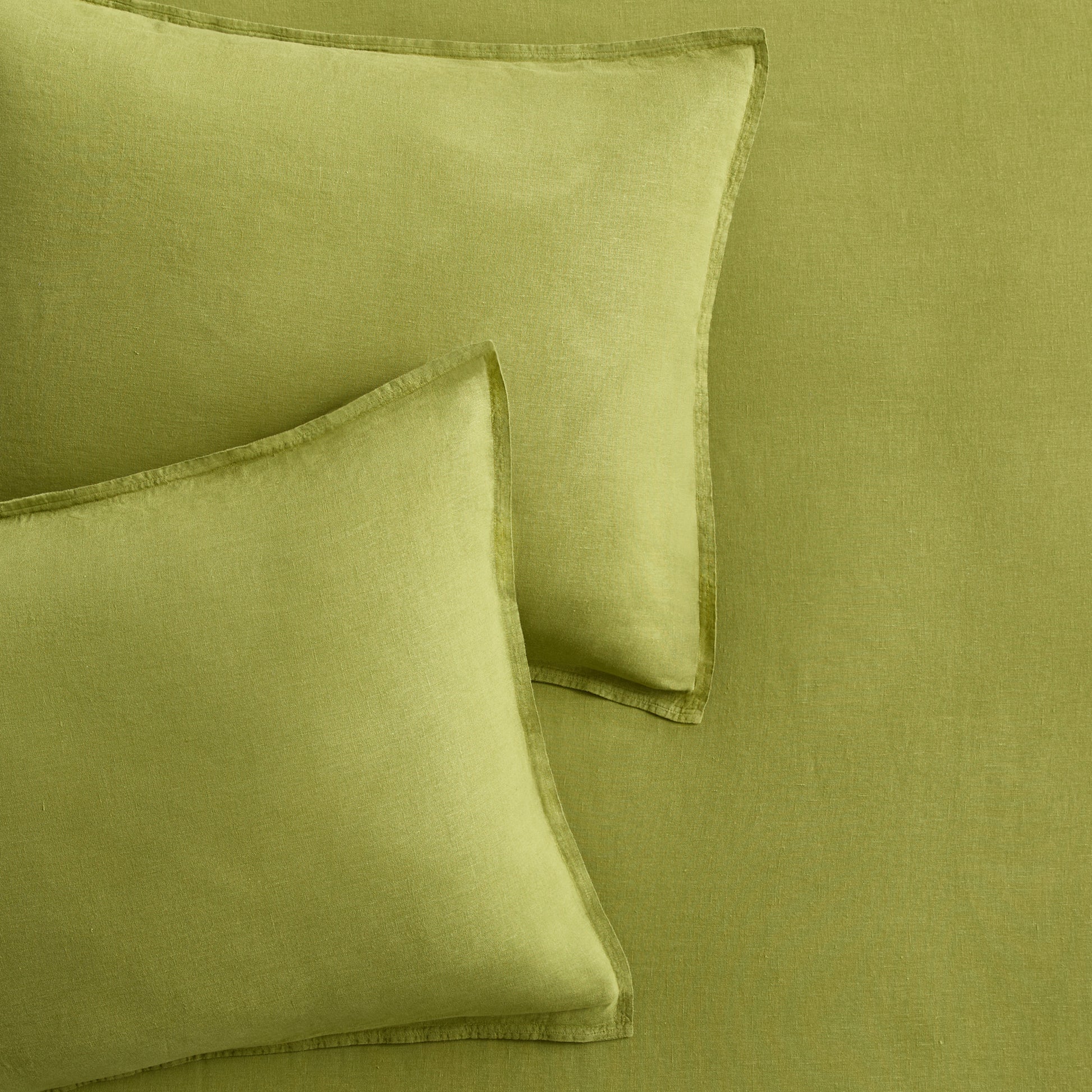 Set of two avocado green European washed linen euro shams with a soft, textured finish.