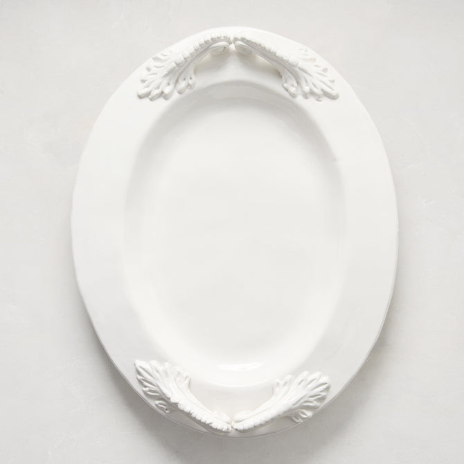 White ceramic oval serving platter with decorative artisanal handles.
