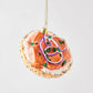 Hand-painted glass bagel and lox Christmas ornament with cream cheese, red onion, capers, and poppy seed details.
