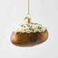 Hand-painted glass and resin baked potato Christmas ornament with glittery brown skin and white toppings.