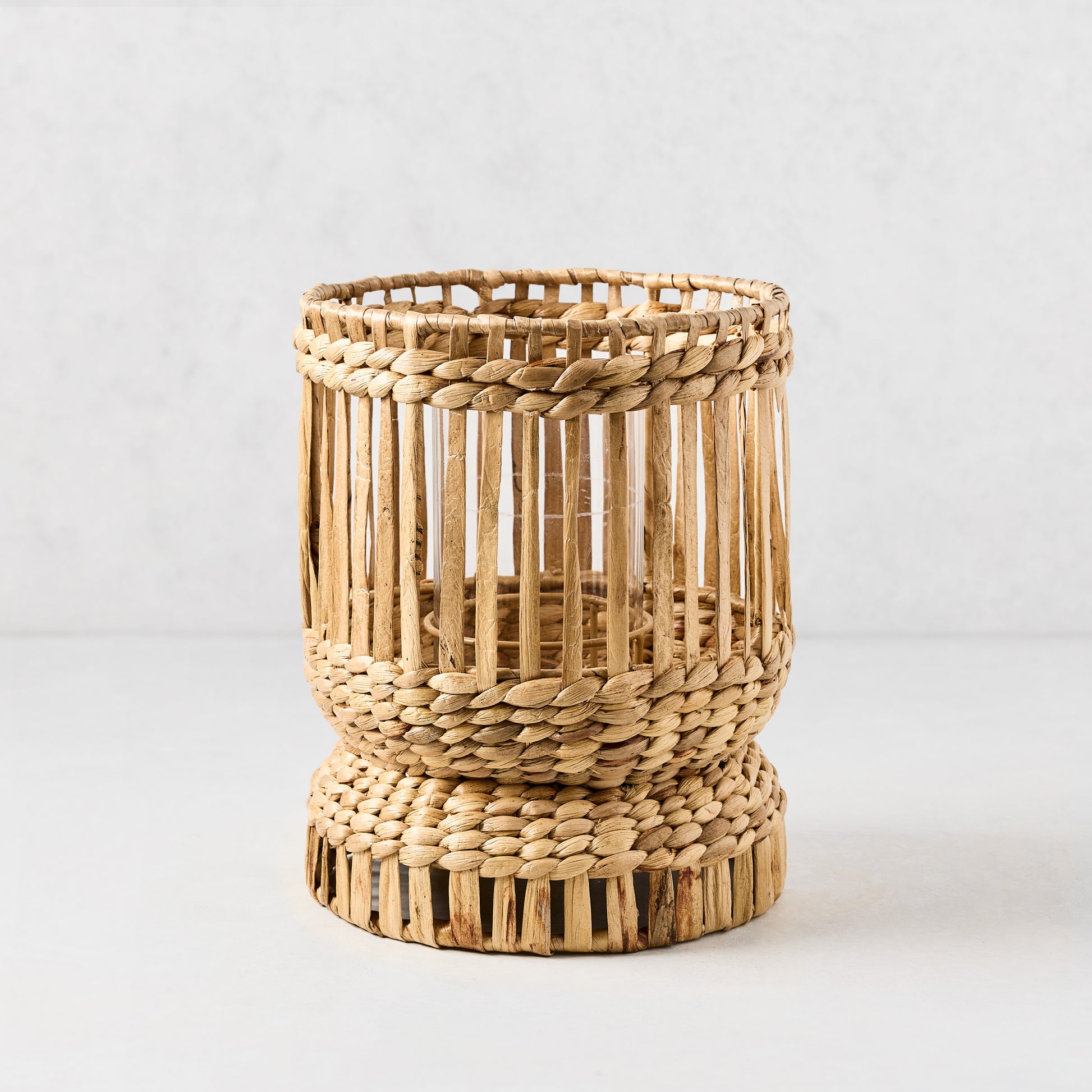 Medium Bali Woven Hyacinth Hurricane, natural tan, with glass insert and full-length woven pattern.
