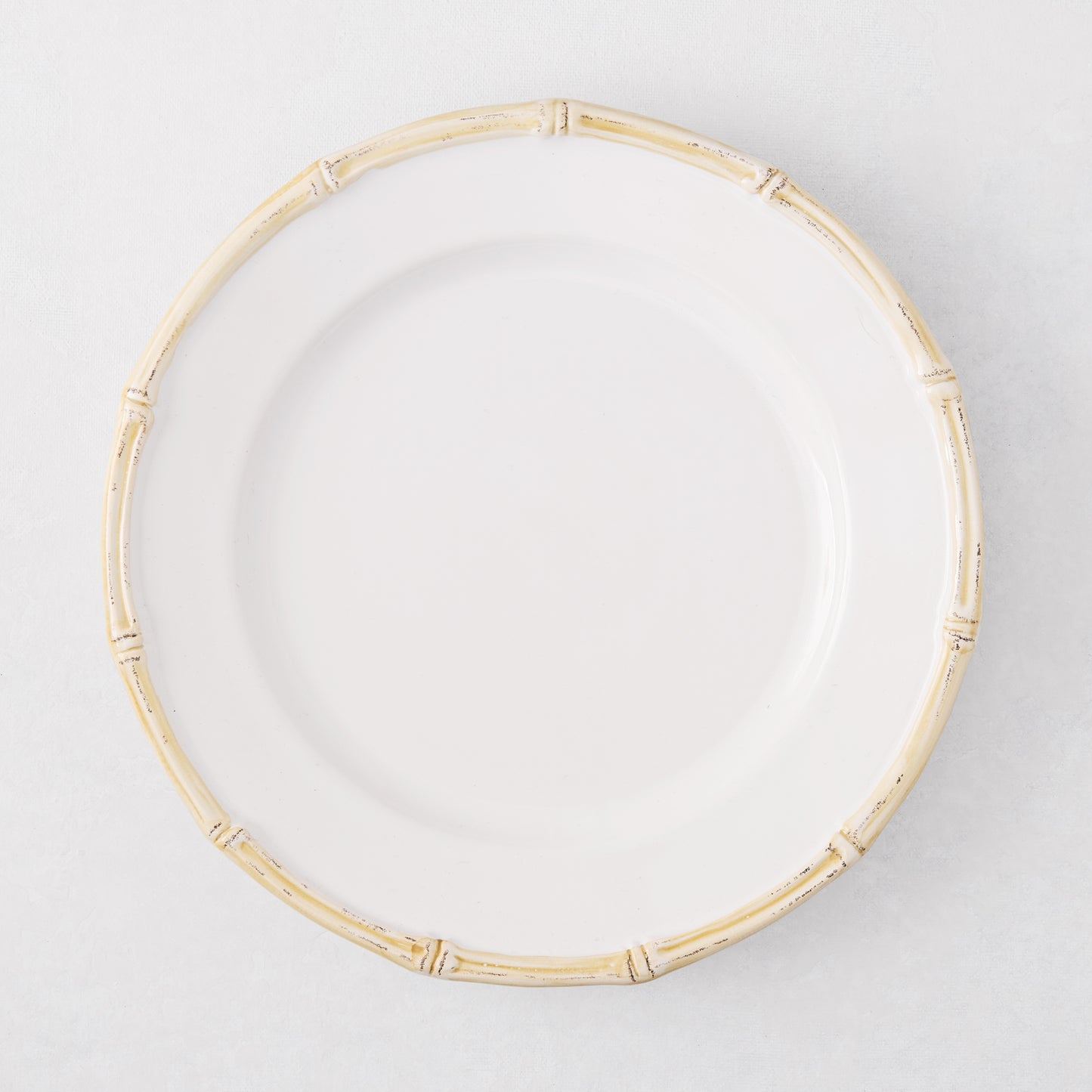 White ceramic salad plate with a natural-edged, bamboo-molded rim.